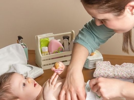 Nurse changing baby diaper
